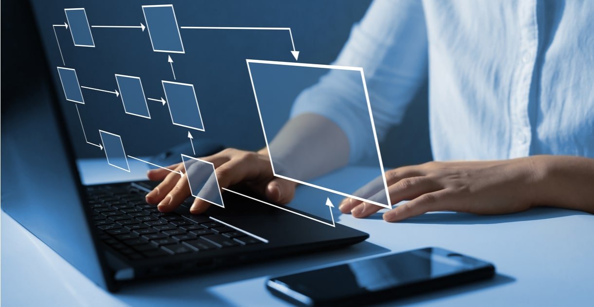 Persona trabajando en laptop con un diagrama de flujo de proceso superpuesto